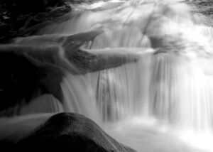 water running over a rapid in black and white